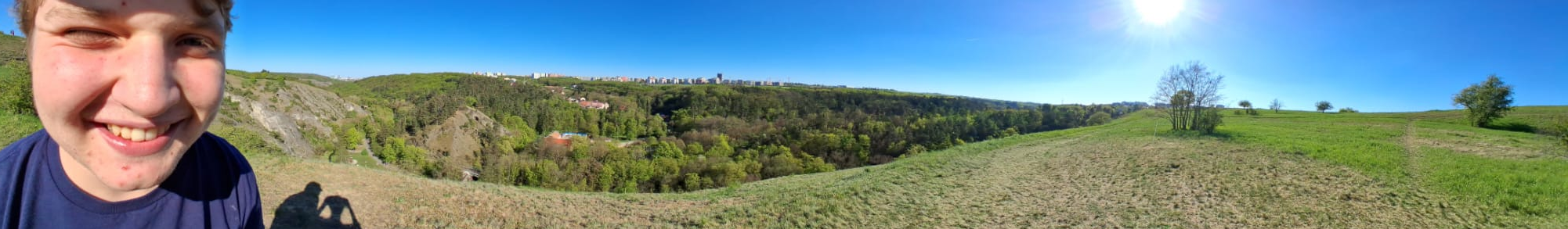 a beautiful panoramatic shot of a valley with a modern urban development in the background located at an unspecified location in Prague, Czech Republic, Europe, The World, with the idiotic face of this subpage's owner looking like himself